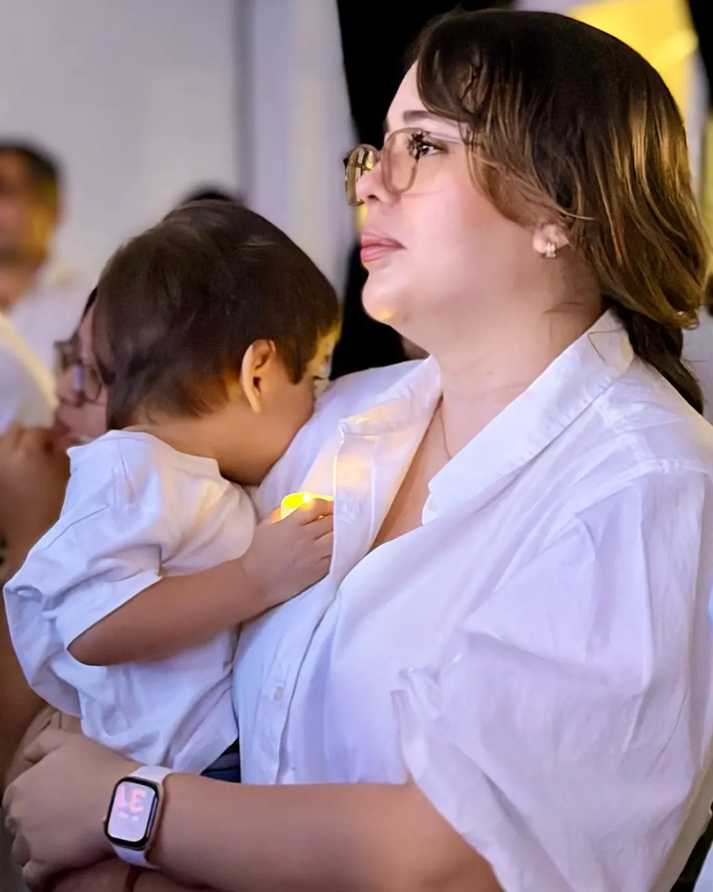 Una madre con su hijo en brazos durante el culto